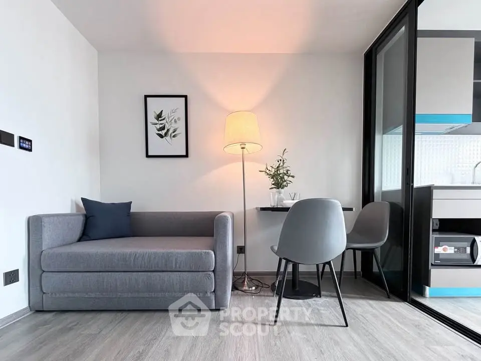 Modern living room with sleek gray sofa and stylish kitchen area