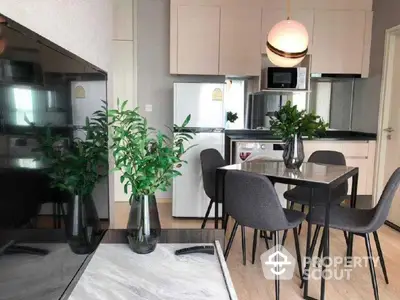 Modern kitchen with stainless steel appliances, ample cabinetry, and a sleek dining area, complemented by chic decor and natural light.