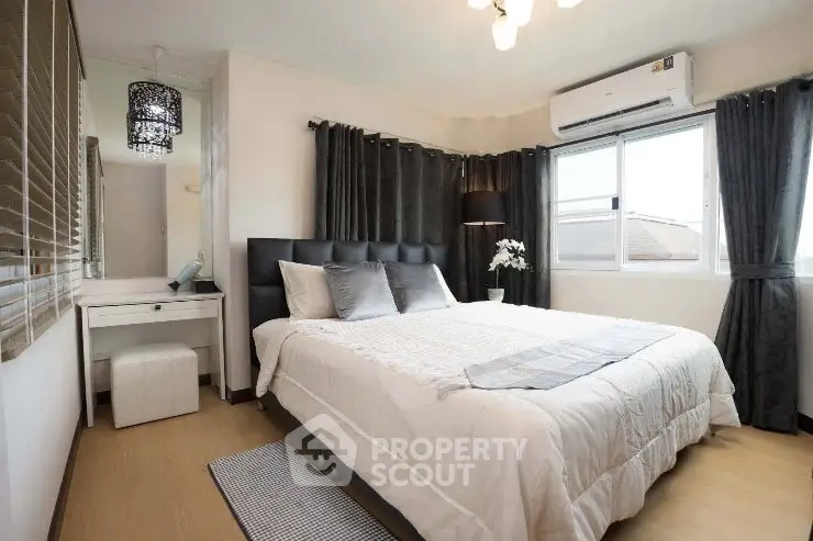 Modern bedroom with stylish decor, large window, and cozy ambiance.