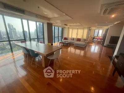 Spacious modern living room with panoramic city views and elegant wooden flooring.
