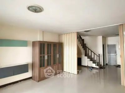 Spacious living room with modern staircase and sleek storage solutions