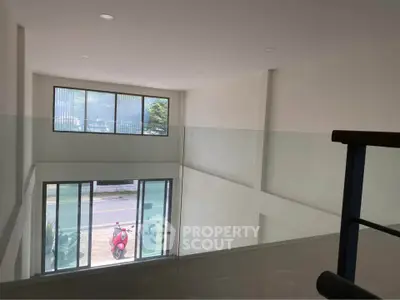 Spacious modern interior with large windows and street view, ideal for natural light lovers.