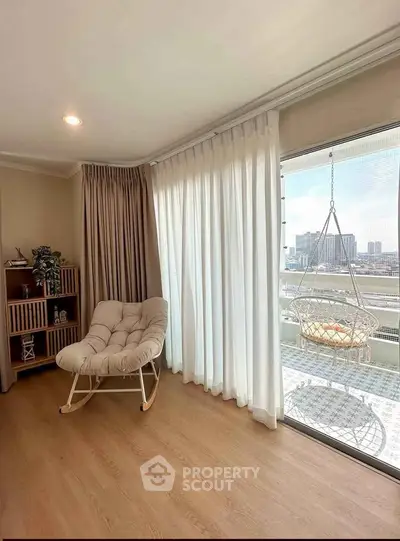 Bright living room with cozy chair and balcony view in modern apartment