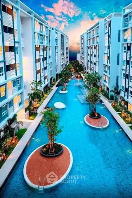 Luxurious apartment complex with stunning central pool and modern architecture at sunset.