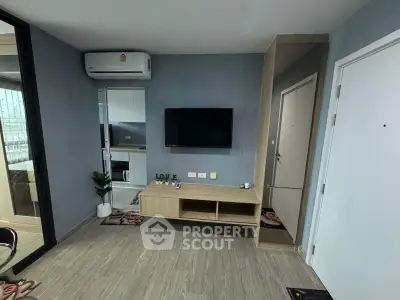 Modern living room with sleek TV setup and stylish decor in a contemporary apartment.