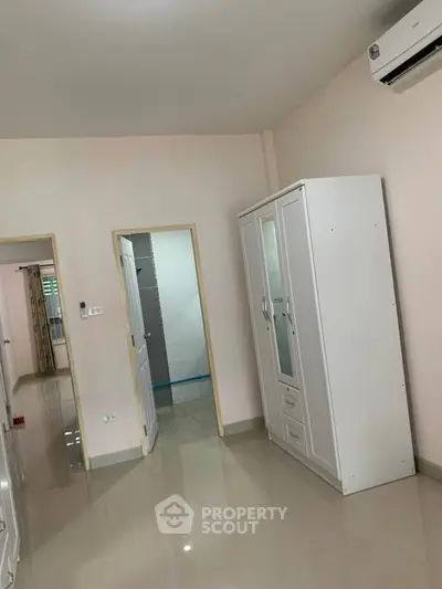 Spacious bedroom with sleek wardrobe and air conditioning unit, perfect for modern living.