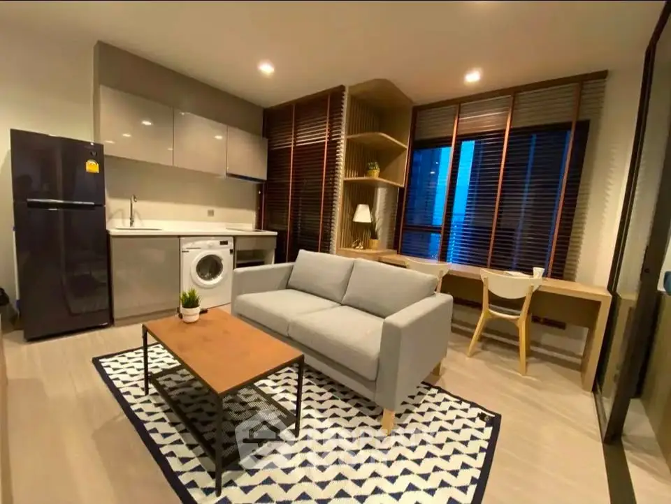 Modern living room with stylish furniture, open kitchen, and large windows in a cozy apartment.