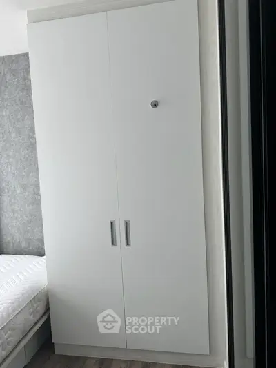 Modern bedroom with sleek white wardrobe and cozy bed setup