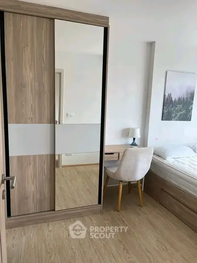 Modern bedroom with stylish wooden wardrobe and cozy workspace