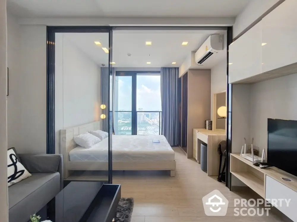 Modern bedroom with city view, featuring sleek furnishings and natural light.