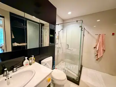 Modern bathroom with glass shower and sleek black cabinetry