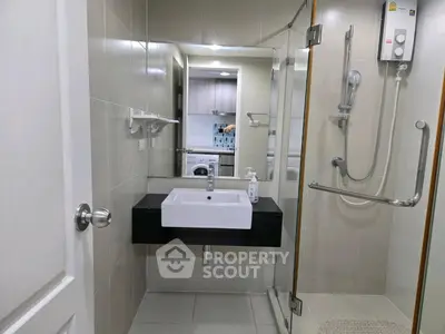 Modern bathroom with sleek fixtures and glass shower enclosure in a contemporary apartment.