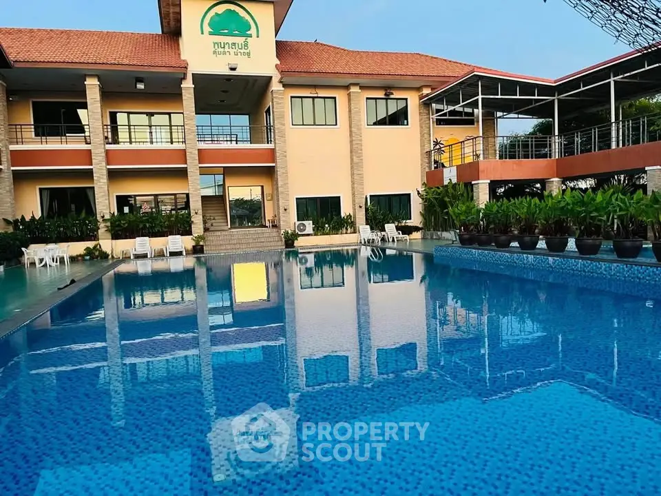 Stunning poolside view of a modern building with lush greenery and spacious outdoor area.