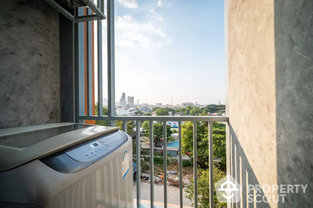 Spacious balcony with modern washing machine overlooking a scenic cityscape, perfect for urban living with a touch of nature.