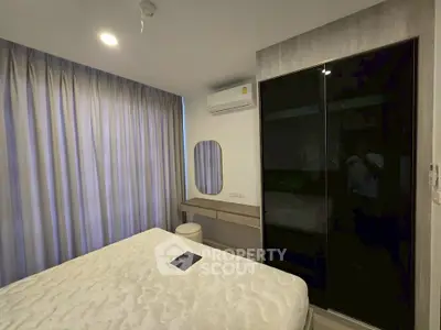 Modern bedroom with sleek design, featuring a large bed, mirrored wardrobe, and stylish vanity area.