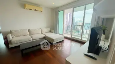 Spacious living room with modern furniture and city view balcony in luxury apartment.