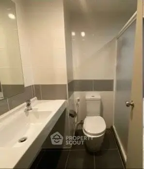 Modern bathroom with sleek design and spacious layout, featuring a large mirror and contemporary fixtures.