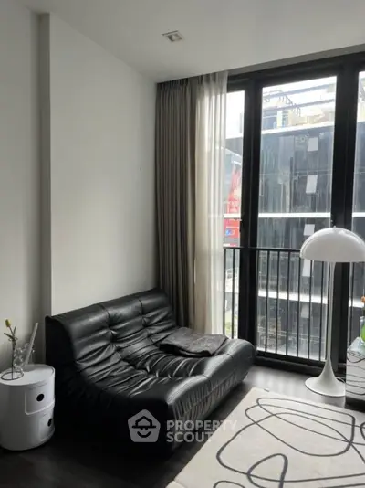 Modern living room with black leather sofa and floor-to-ceiling windows