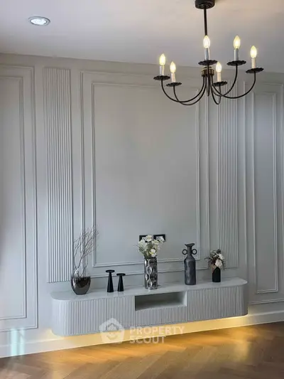 Elegant living room with modern chandelier and decorative wall paneling