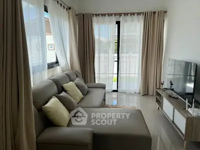 Spacious living room with modern sofa and large windows for natural light.