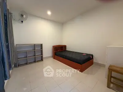 Minimalist bedroom with single bed and shelving, ideal for compact living.