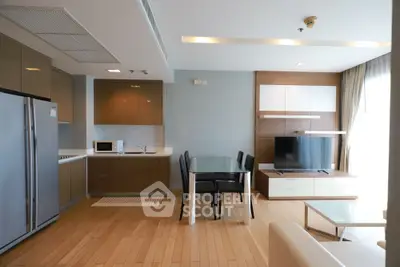 Modern open-layout kitchen and living room with sleek appliances and stylish furniture.