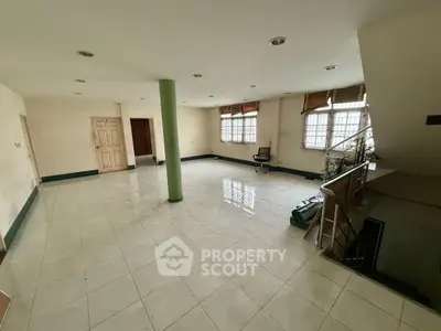 Spacious open-plan interior with tiled flooring and staircase, ideal for customization.