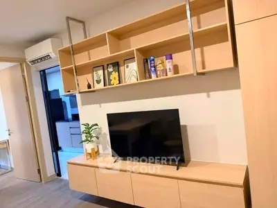 Modern living room with sleek wooden shelves and TV unit, showcasing minimalist design and functionality.