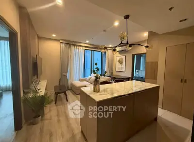 Modern living room with open kitchen and stylish decor in a cozy apartment.