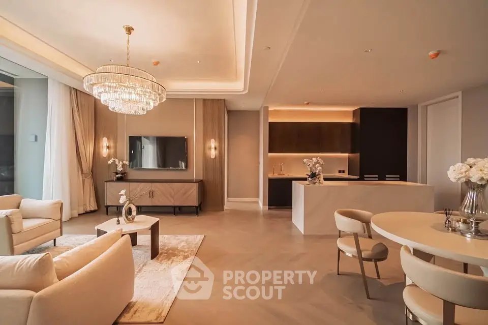 Luxurious open-plan living room with elegant chandelier and modern kitchen