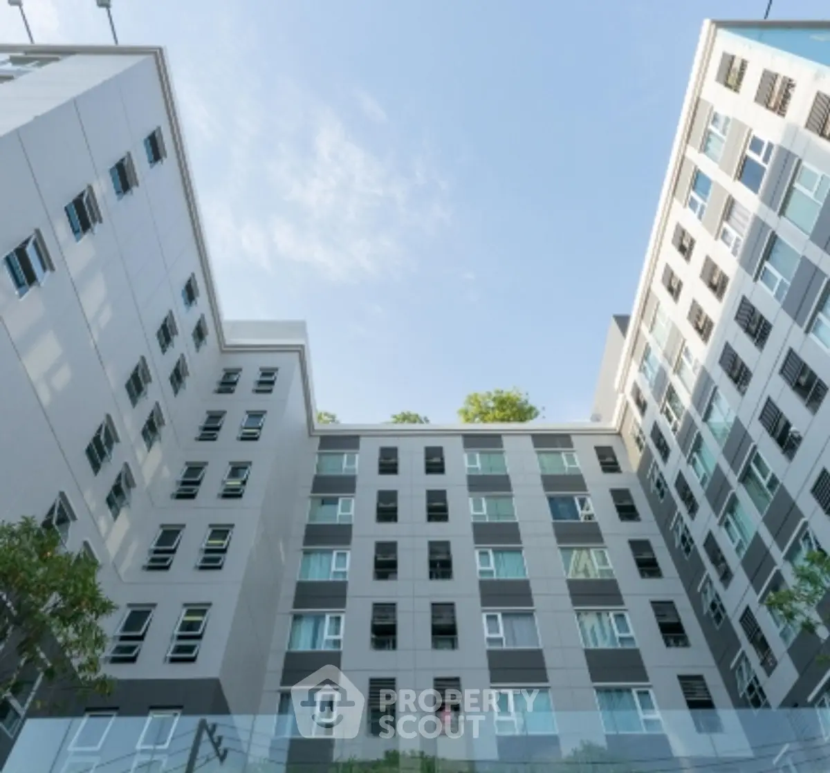 Modern apartment building exterior with sleek design and large windows, showcasing urban living.