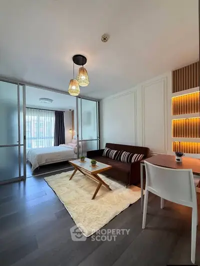 Modern studio apartment with stylish living area and cozy bedroom, featuring elegant lighting and contemporary decor.