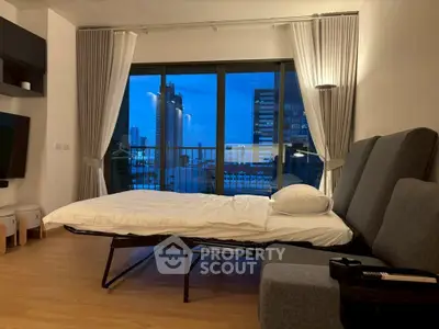 Modern living room with sofa bed and city view balcony at dusk