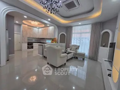 Luxurious living room with elegant chandelier and modern open kitchen layout.