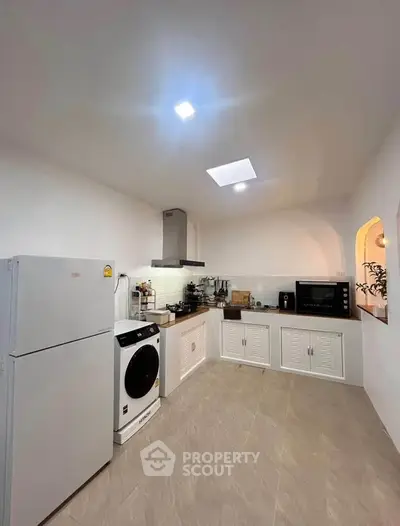Spacious modern kitchen with sleek appliances and ample storage space.