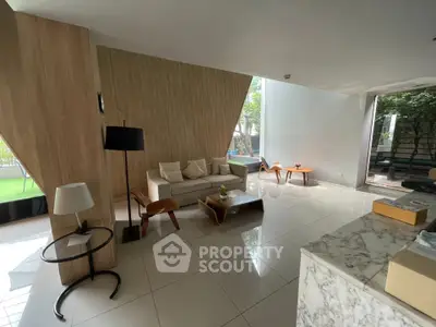 Modern living room with stylish furniture and large windows offering garden views.