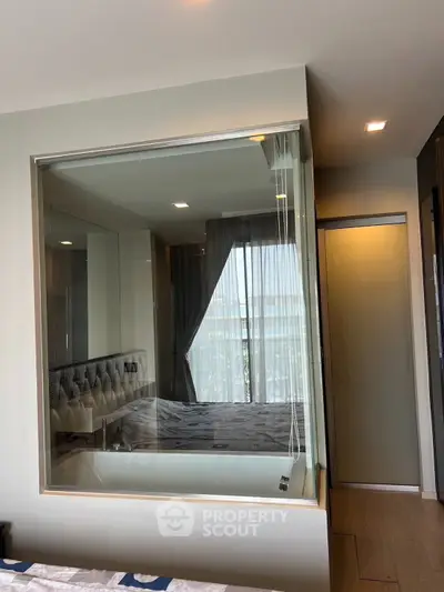 Modern bedroom with glass-enclosed bathtub and large window view