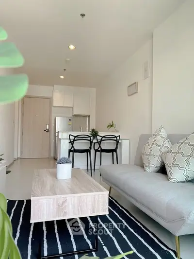 Modern living room with stylish decor and open kitchen layout in a bright apartment.