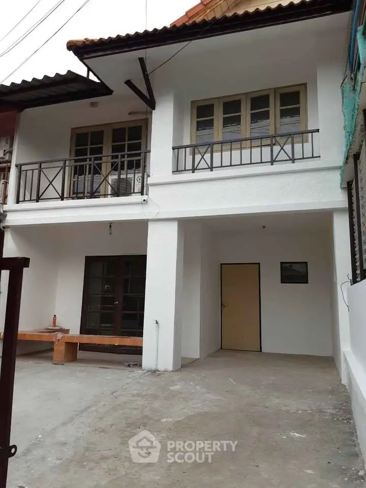 Charming two-story townhouse with spacious balcony and modern facade, perfect for urban living.