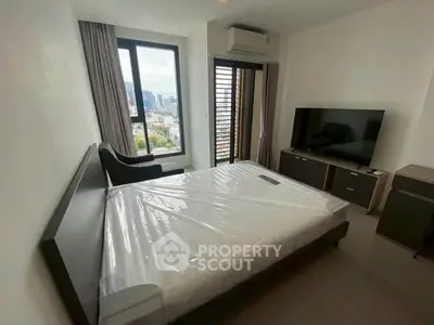 Modern bedroom with city view, featuring a large window, air conditioning, and a flat-screen TV.