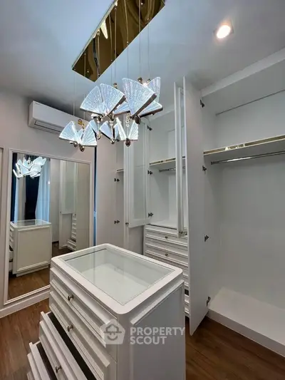 Luxurious walk-in closet with elegant lighting and ample storage space