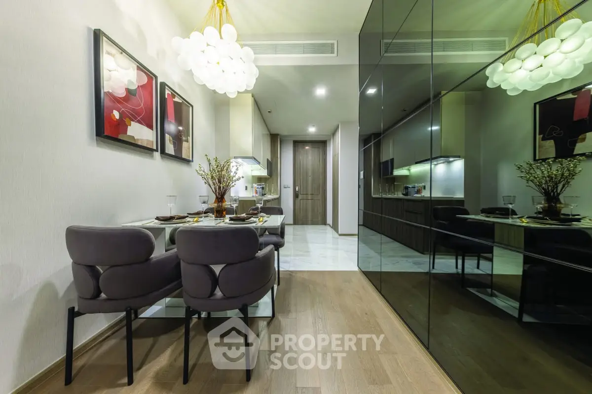 Modern dining area with elegant decor and mirrored wall in a stylish apartment.