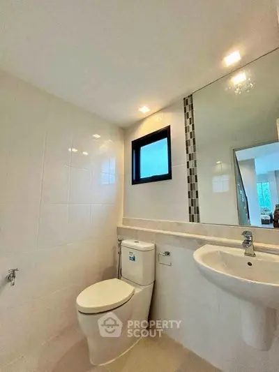 Modern bathroom with sleek fixtures and large mirror in a bright apartment.