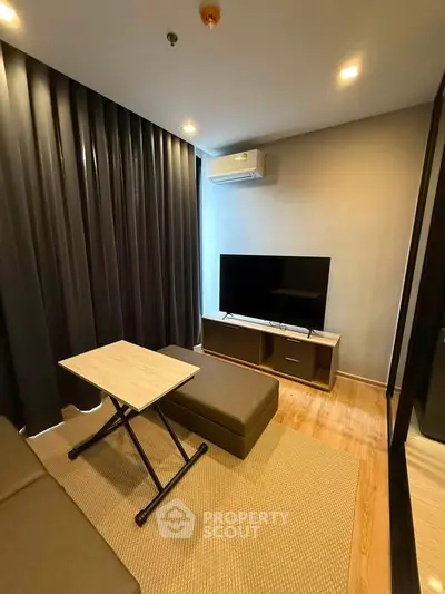Modern living room with sleek furniture and large TV, perfect for relaxation.