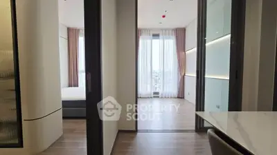 Modern apartment interior with sleek design and large windows offering natural light.