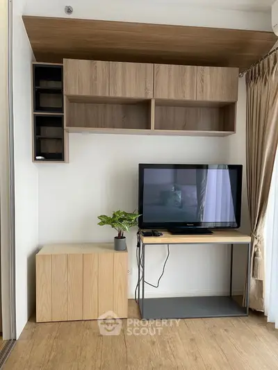 Modern living room with sleek TV stand and wooden cabinets, perfect for stylish urban living.