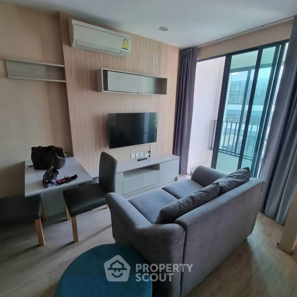 Modern living room with sleek furniture and balcony view in a stylish apartment.