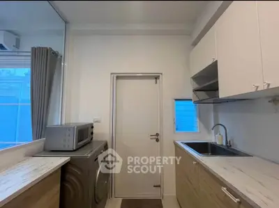 Modern kitchen with sleek cabinetry and integrated appliances in a bright, compact space.