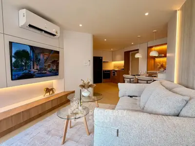 Modern living room with stylish decor and open kitchen layout, featuring cozy seating and ambient lighting.