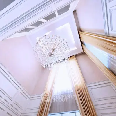 Luxurious high ceiling with elegant chandelier and floor-to-ceiling curtains in a sophisticated living space.